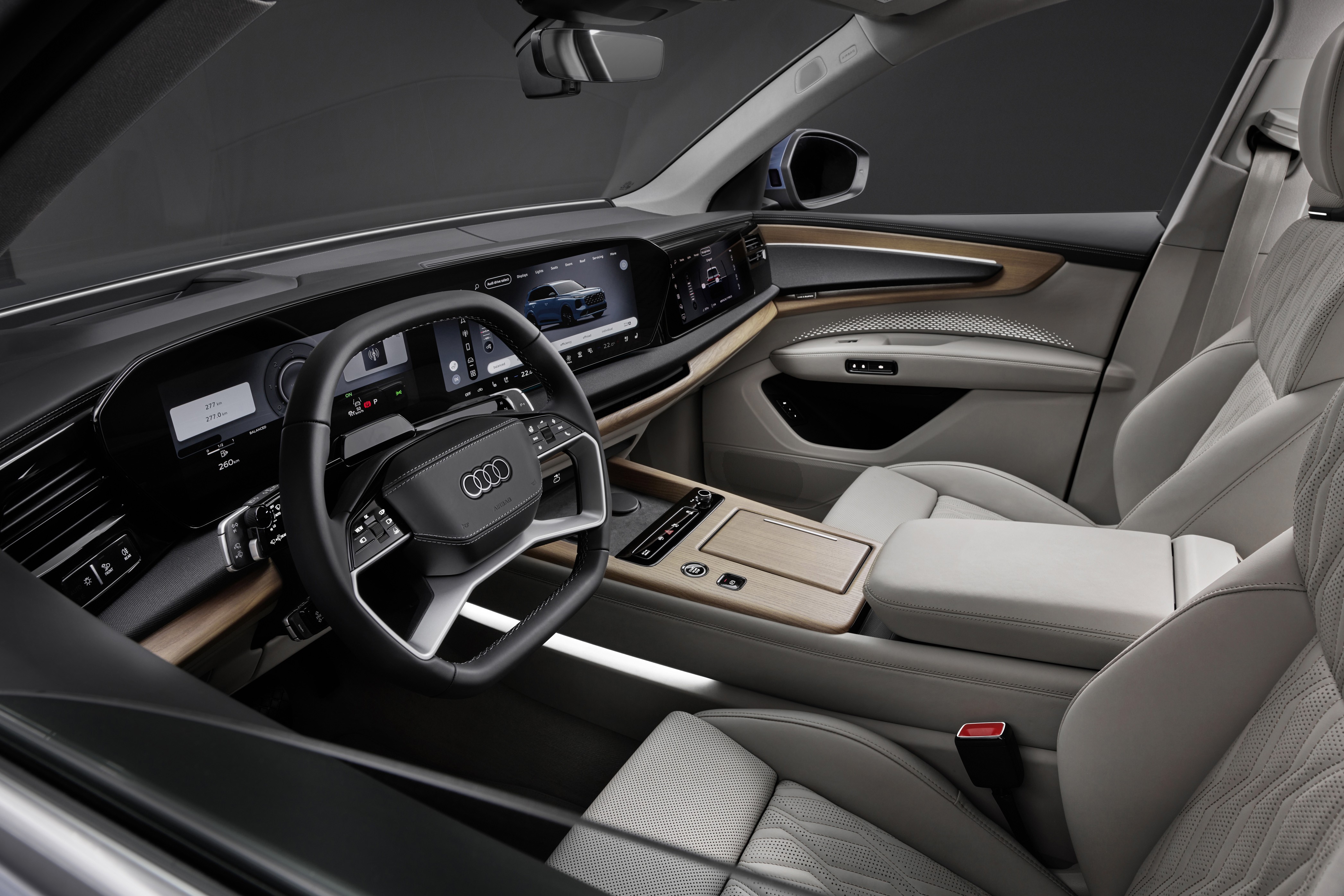 Interior de um carro Audi moderno, com volante multifuncional preto e o logotipo da marca. O painel possui várias telas digitais exibindo informações e um carro azul. Os bancos são de couro claro, e o console central tem acabamento em madeira clara, com botões e um apoio de braço estofado. O ambiente é sofisticado e tecnológico
