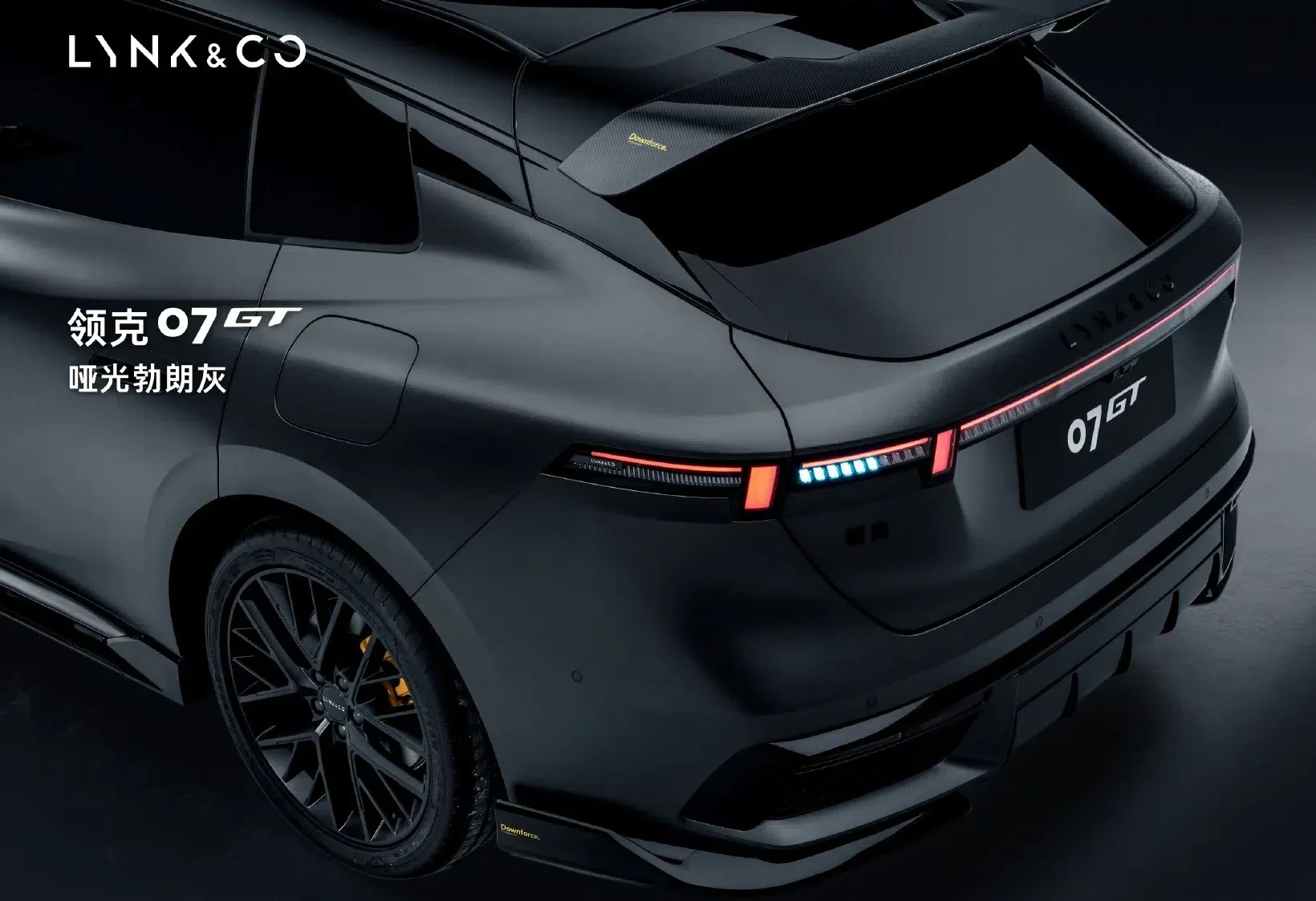 Traseira de um carro Link & Co 07 GT cinza fosco, com lanternas LED vermelhas e azuis acesas, aerofólio e rodas pretas esportivas. O fundo é escuro, destacando o veículo