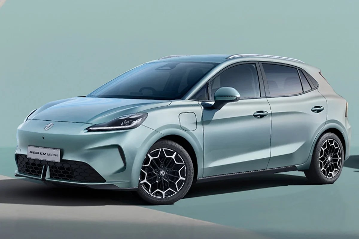 Carro elétrico MG EV Urban hatch, cor verde-água, visto de frente e lateral, com rodas pretas e detalhes brancos, em fundo azul claro