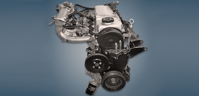 Motor de carro em preto e branco, com diversas peças metálicas e mangueiras visíveis, sobre um fundo azul escuro