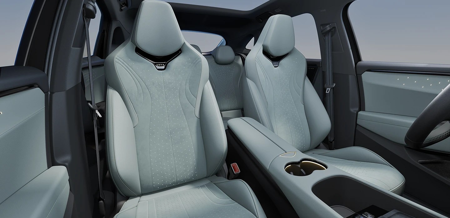 Interior de carro moderno com bancos dianteiros e traseiros em tom verde-água claro, console central com porta-copos e detalhes em preto, e teto solar panorâmico. Os bancos possuem costuras decorativas e perfurações sutis.