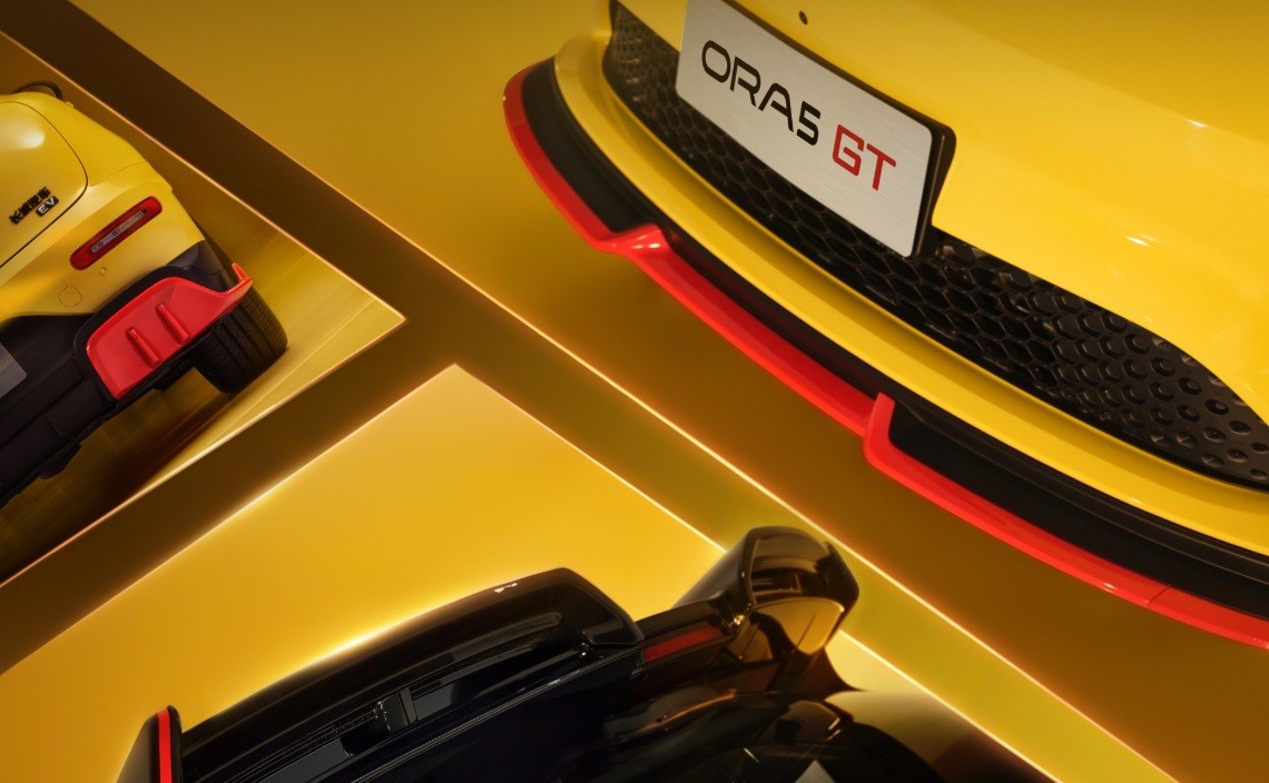Detalhe de três carros esportivos amarelos com detalhes em vermelho e preto, exibidos em plataformas amarelas iluminadas. Um carro aparece no canto superior esquerdo, outro no canto superior direito com a placa ORAS GT, e o terceiro na parte inferior central