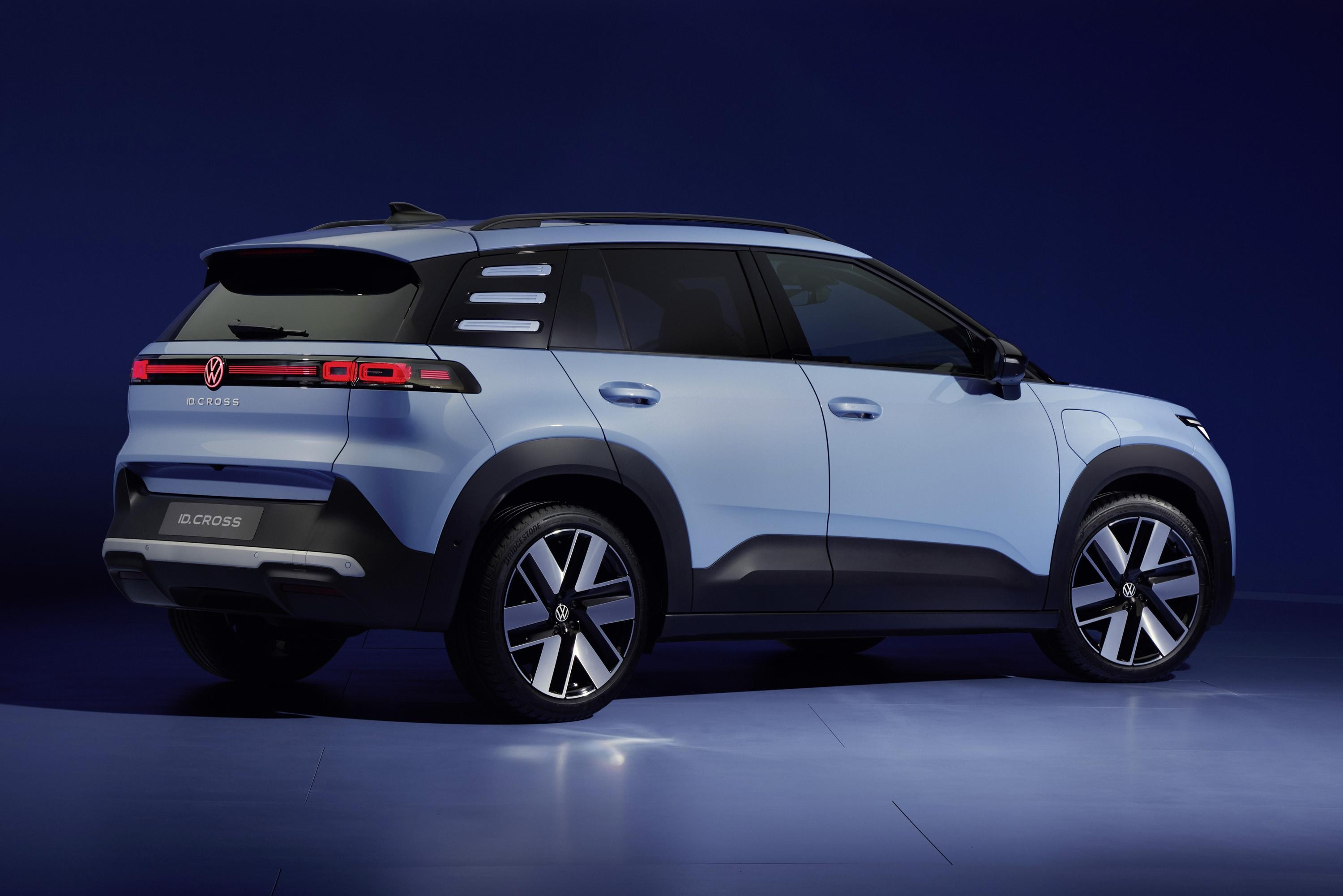 SUV Volkswagen ID. Cross azul claro, com detalhes pretos e rodas de liga leve, visto de traseira e lateral, sobre um fundo azul escuro