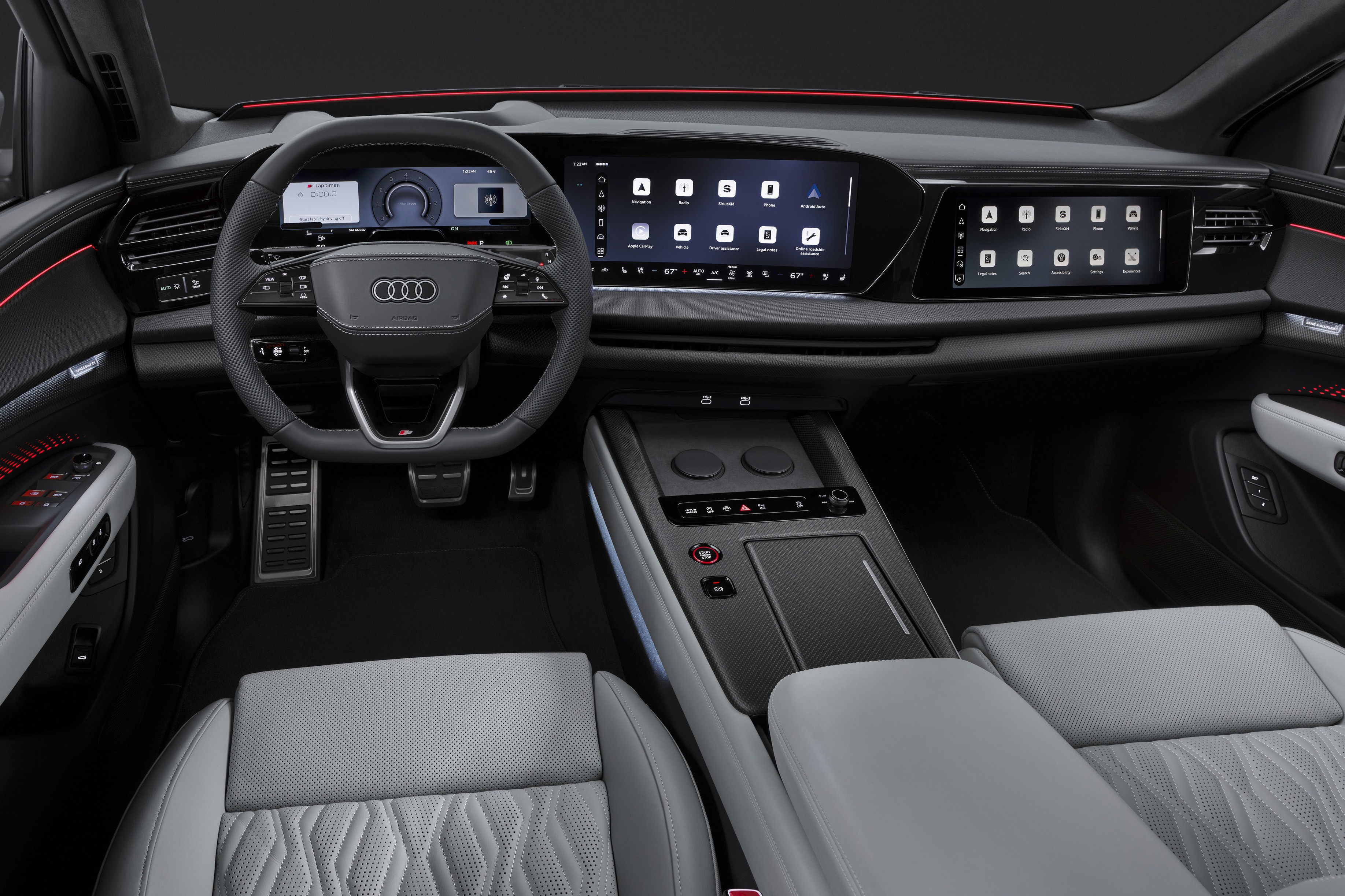 Interior de um carro Audi moderno, com volante preto, painel digital e duas telas sensíveis ao toque exibindo ícones de aplicativos. Os bancos são cinza claro com detalhes em relevo, e há iluminação ambiente vermelha e azul em algumas partes do painel e portas