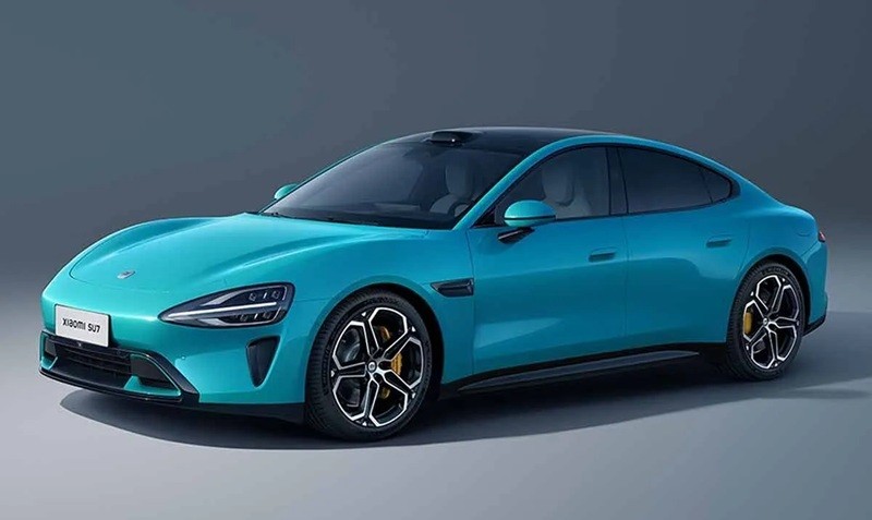 Carro elétrico Xiaomi SU7 azul-turquesa, com teto preto e rodas esportivas pretas e prateadas, parado em um estúdio com fundo cinza