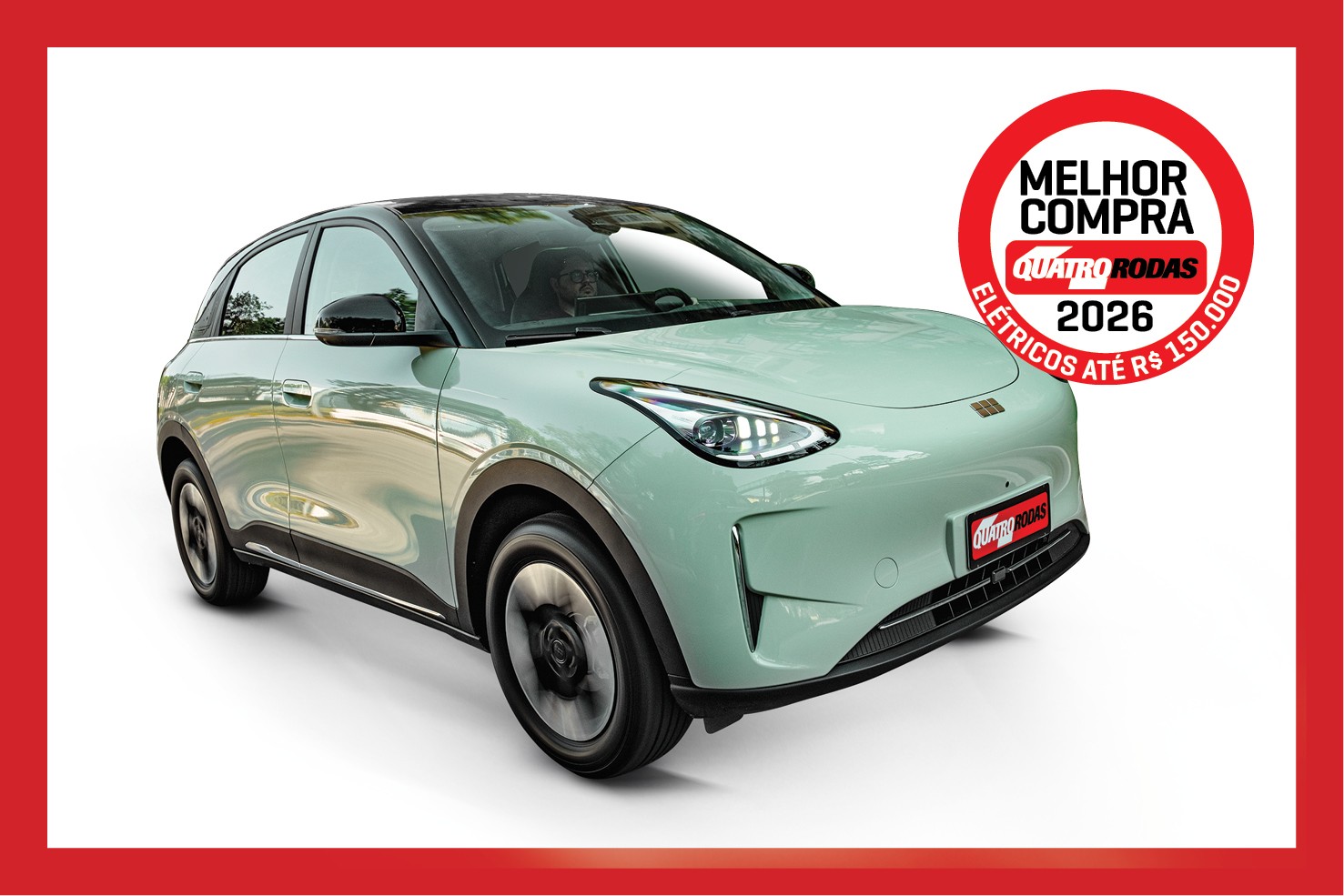 Carro elétrico verde-água com teto preto, visto de frente e lateral, em fundo branco. Um selo vermelho no canto superior direito indica MELHOR COMPRA QUATRO RODAS ELÉTRICOS ATÉ R$ 150.000 2026