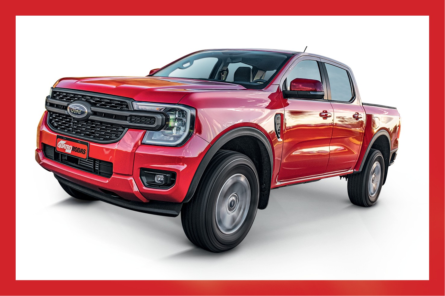 Picape Ford Ranger vermelha, modelo 2023, vista de frente e levemente de lado, com a grade frontal preta e o logotipo da Ford em destaque. O para-choque dianteiro tem faróis de neblina e uma placa vermelha com o texto QUATRO RODAS em branco. O veículo está sobre um fundo branco, com uma borda vermelha ao redor da imagem