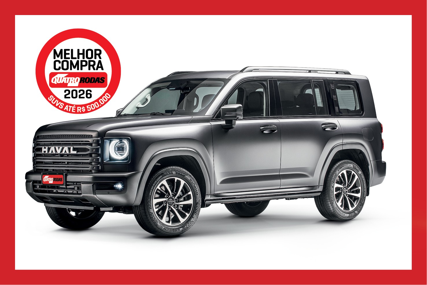 SUV Haval cinza escuro, com faróis acesos, grade frontal preta e rodas esportivas, em fundo branco. Um selo vermelho no canto superior esquerdo indica Melhor Compra Quatro Rodas 2026 SUVs até R$ 500.000