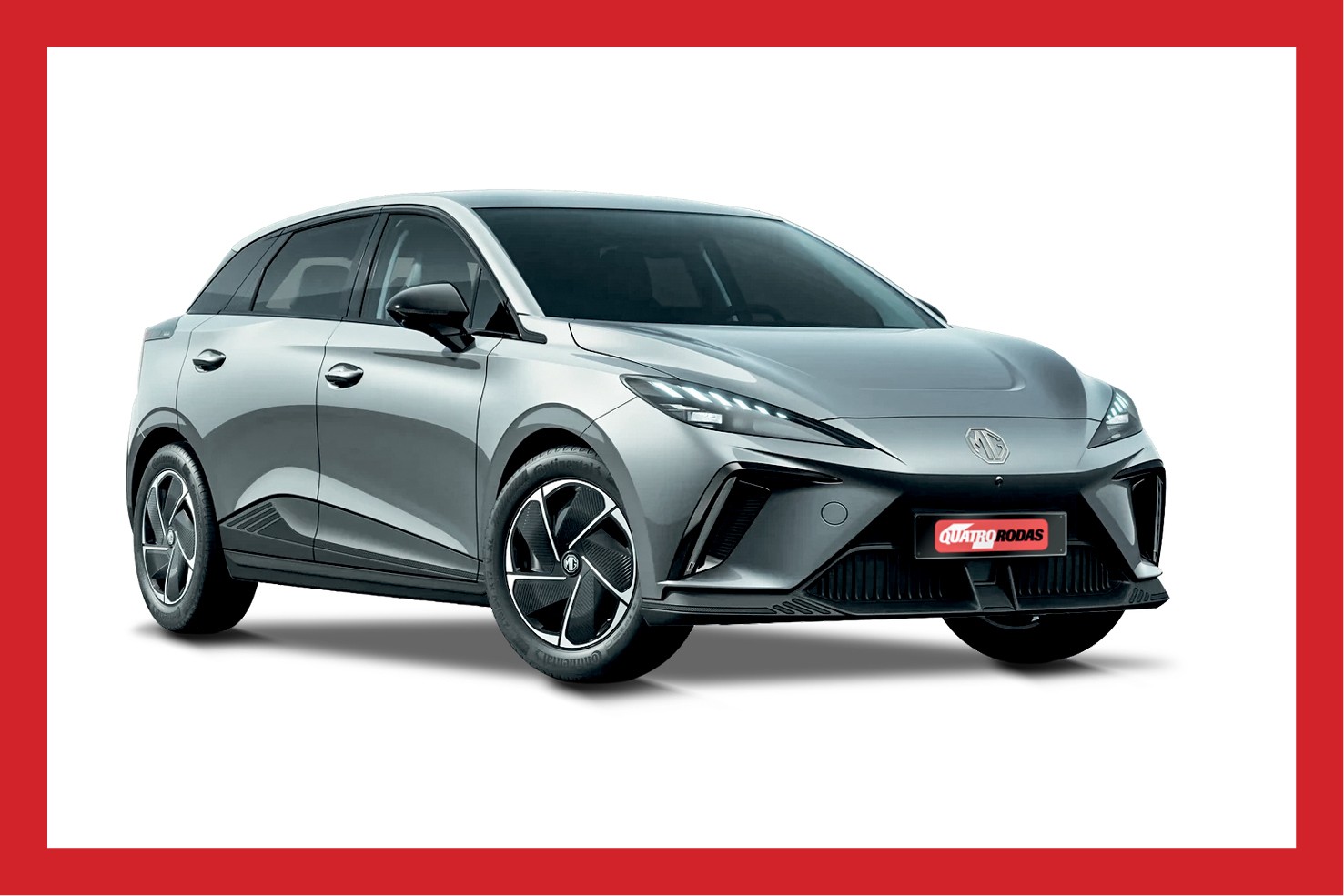 Carro cinza prateado, modelo hatch, com design moderno e esportivo, em fundo branco. O veículo tem faróis afilados com luzes diurnas em LED, grade frontal escura e rodas com detalhes pretos e prateados. O logotipo da Quatro Rodas aparece na parte inferior do para-choque.
