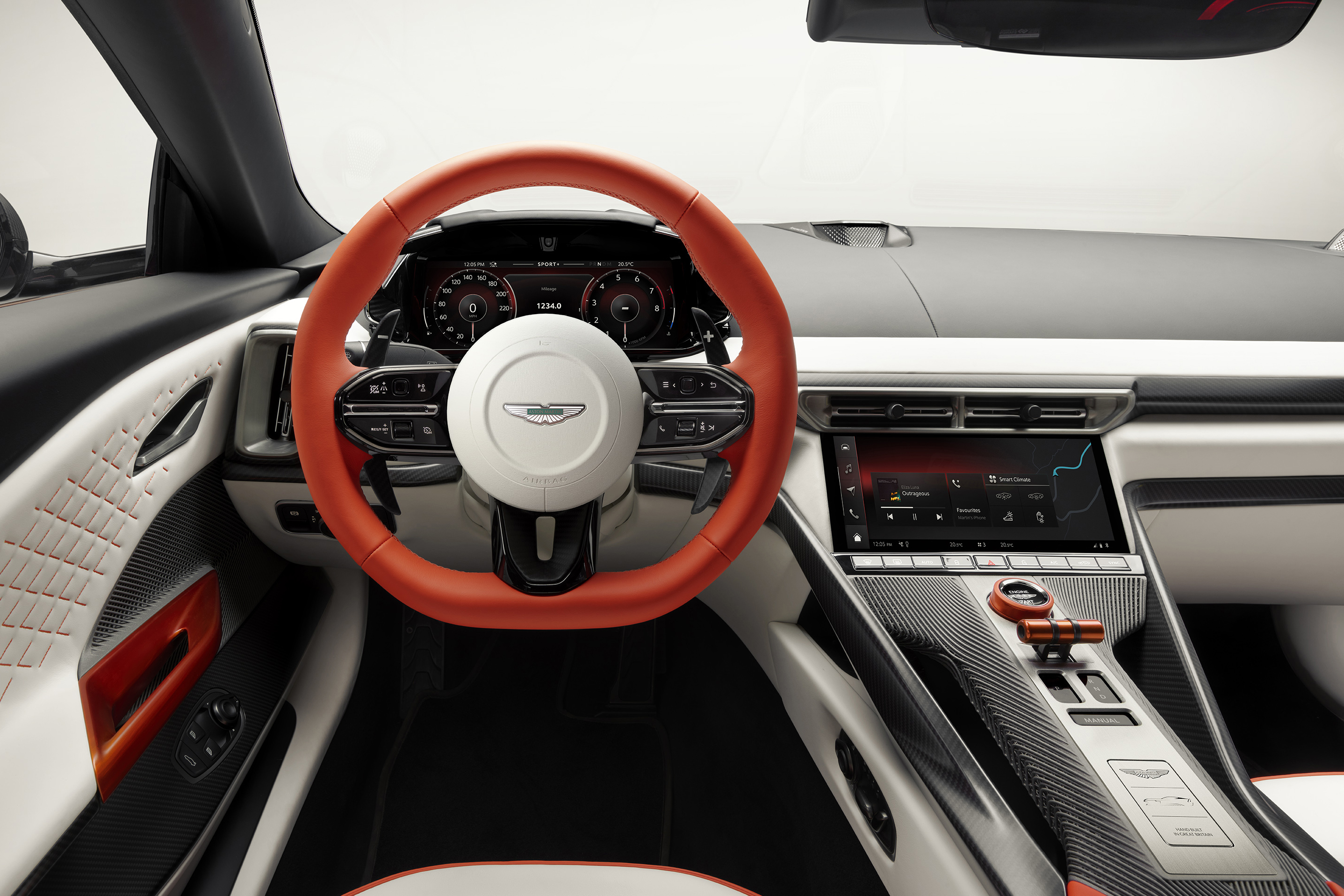 Interior de carro esportivo com volante laranja vibrante e centro branco, painel digital com velocímetro e conta-giros, e tela multimídia exibindo um mapa. Detalhes em fibra de carbono e costura vermelha na porta branca completam o design moderno