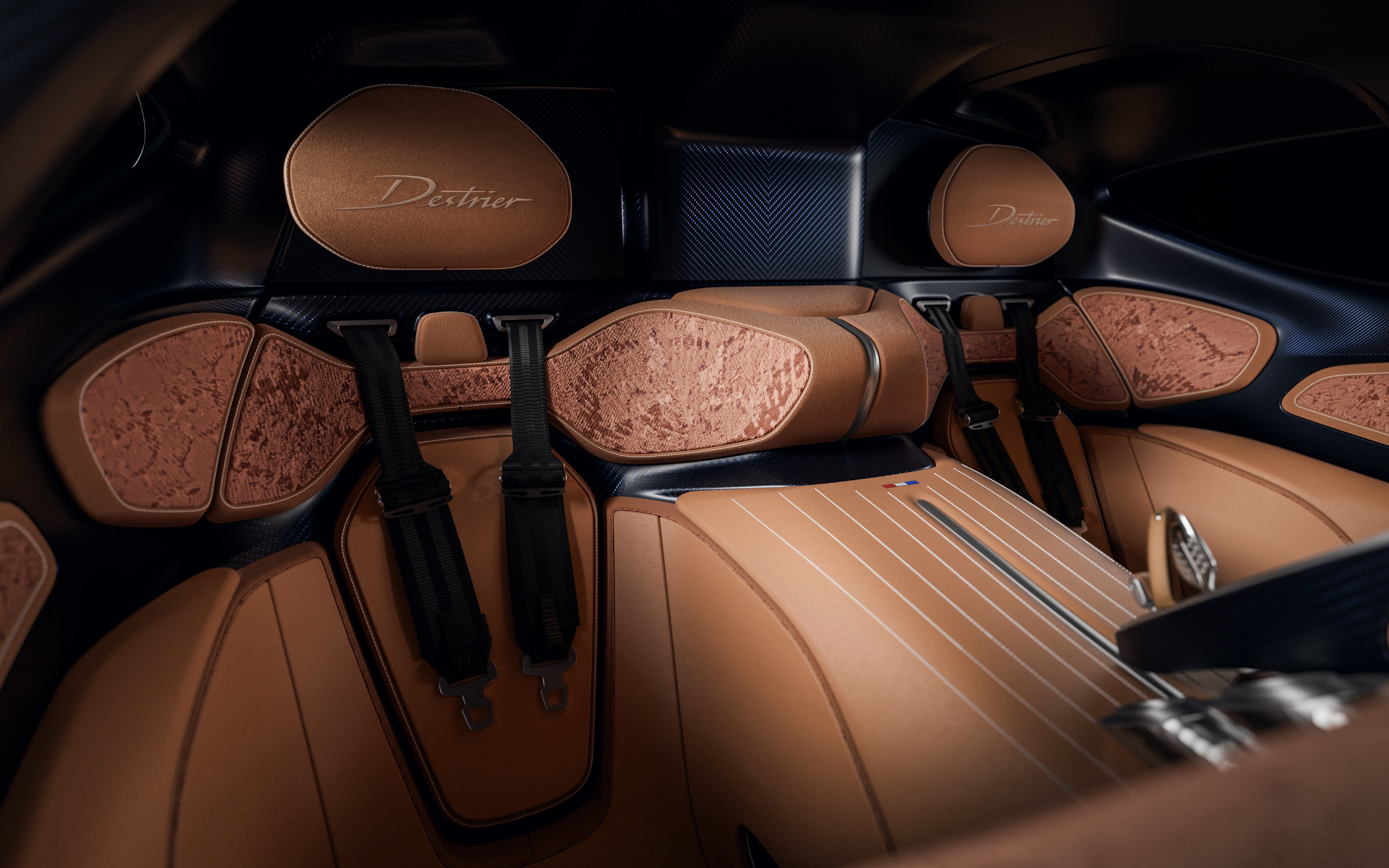 Interior luxuoso de um carro com bancos de couro marrom-claro, detalhes em madeira texturizada e cintos de segurança pretos. O encosto de cabeça tem a palavra Destrier bordada