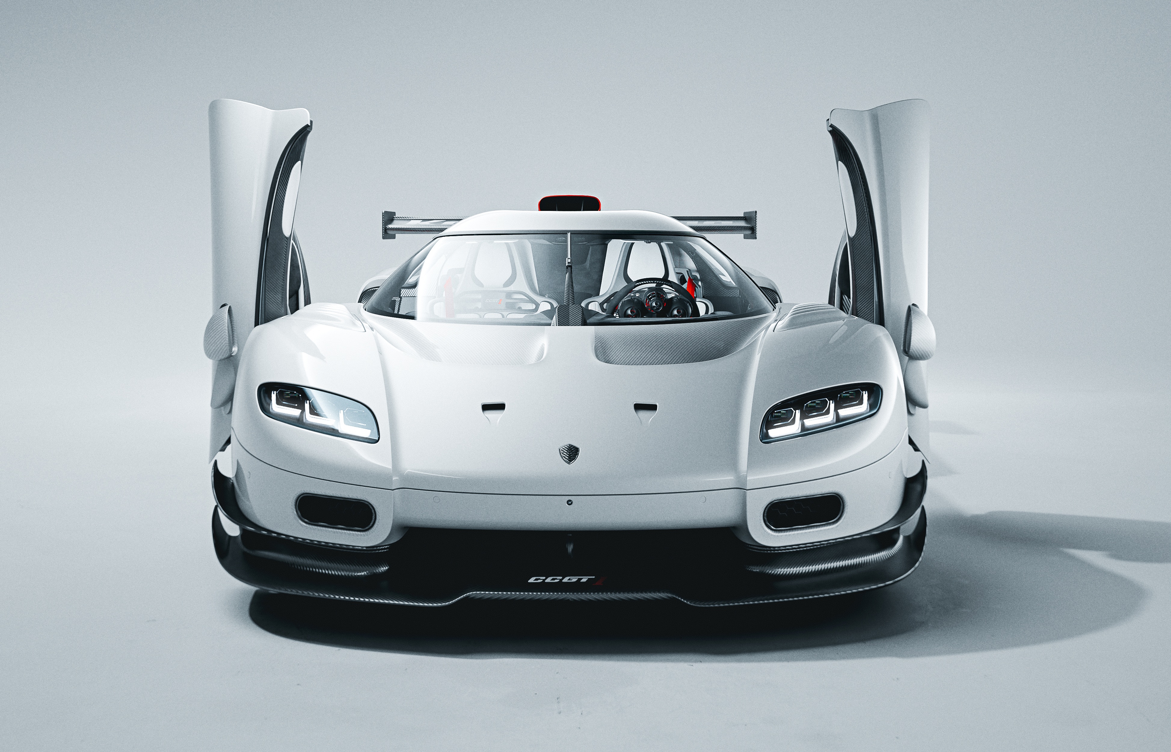 Carro esportivo branco Koenigsegg CCGT, com portas abertas para cima, faróis acesos e aerofólio traseiro, em estúdio claro