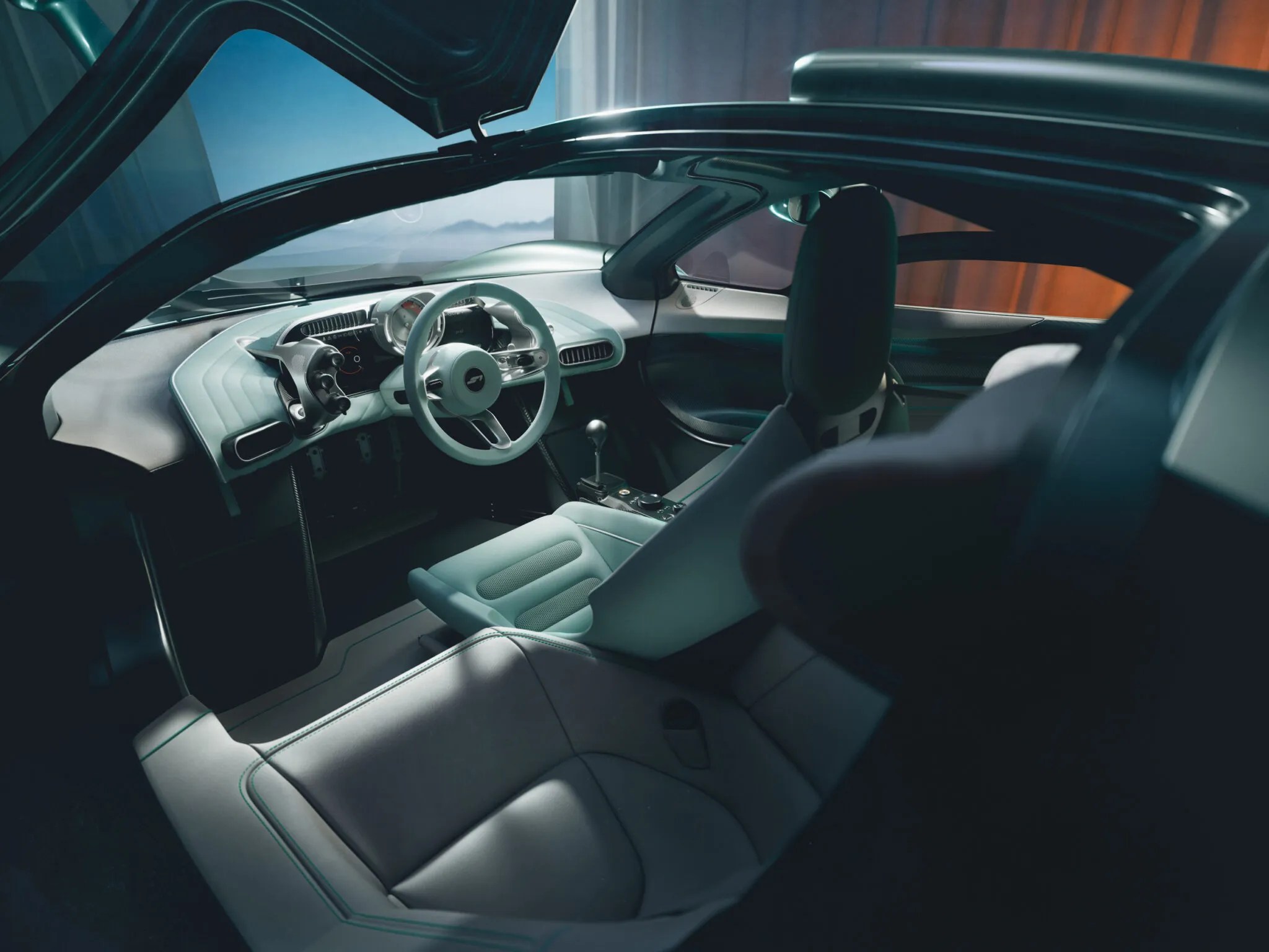 Interior de um carro esportivo moderno, com portas abertas para cima. O painel e o volante são brancos, os bancos dianteiros e traseiros são cinza-claro, com detalhes em verde-água. O ambiente externo, visível pelo para-brisa, é um cenário montanhoso com céu azul