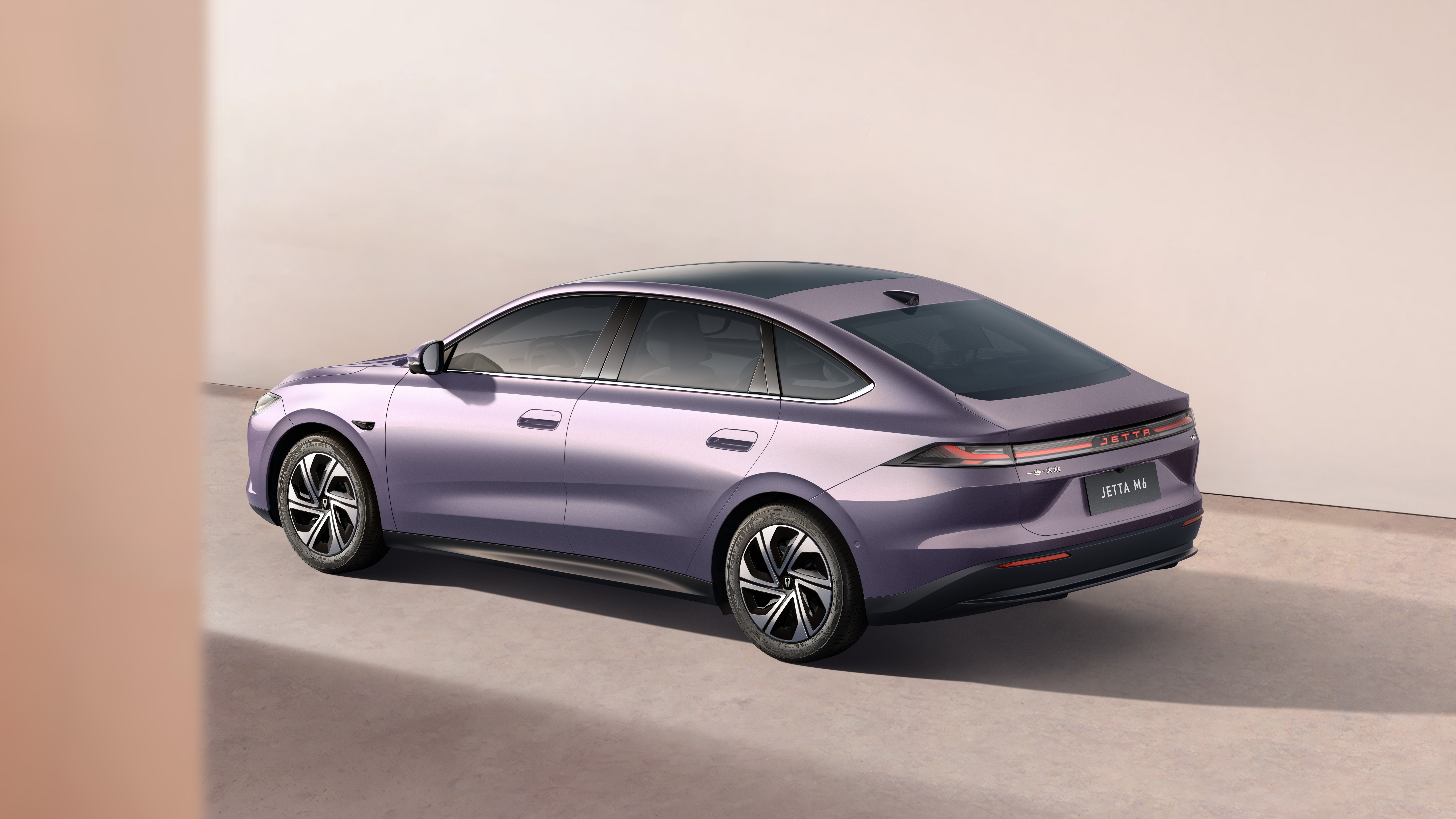 Carro sedan roxo metálico, modelo Jetta MA, visto de três quartos traseiro, estacionado em um ambiente minimalista com parede clara e chão cinza
