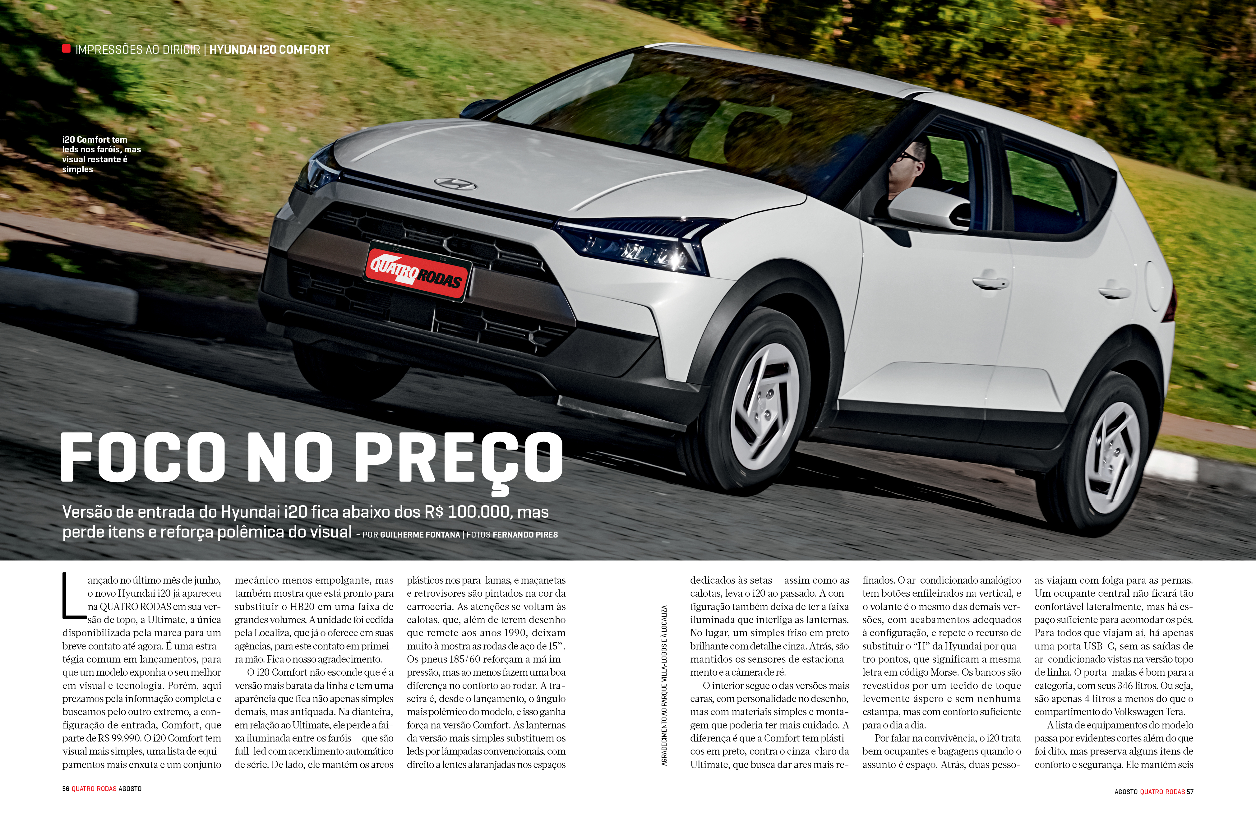 Um carro Hyundai i20 branco com detalhes pretos na frente e nas laterais, dirigido por uma pessoa, em uma estrada com grama verde ao fundo