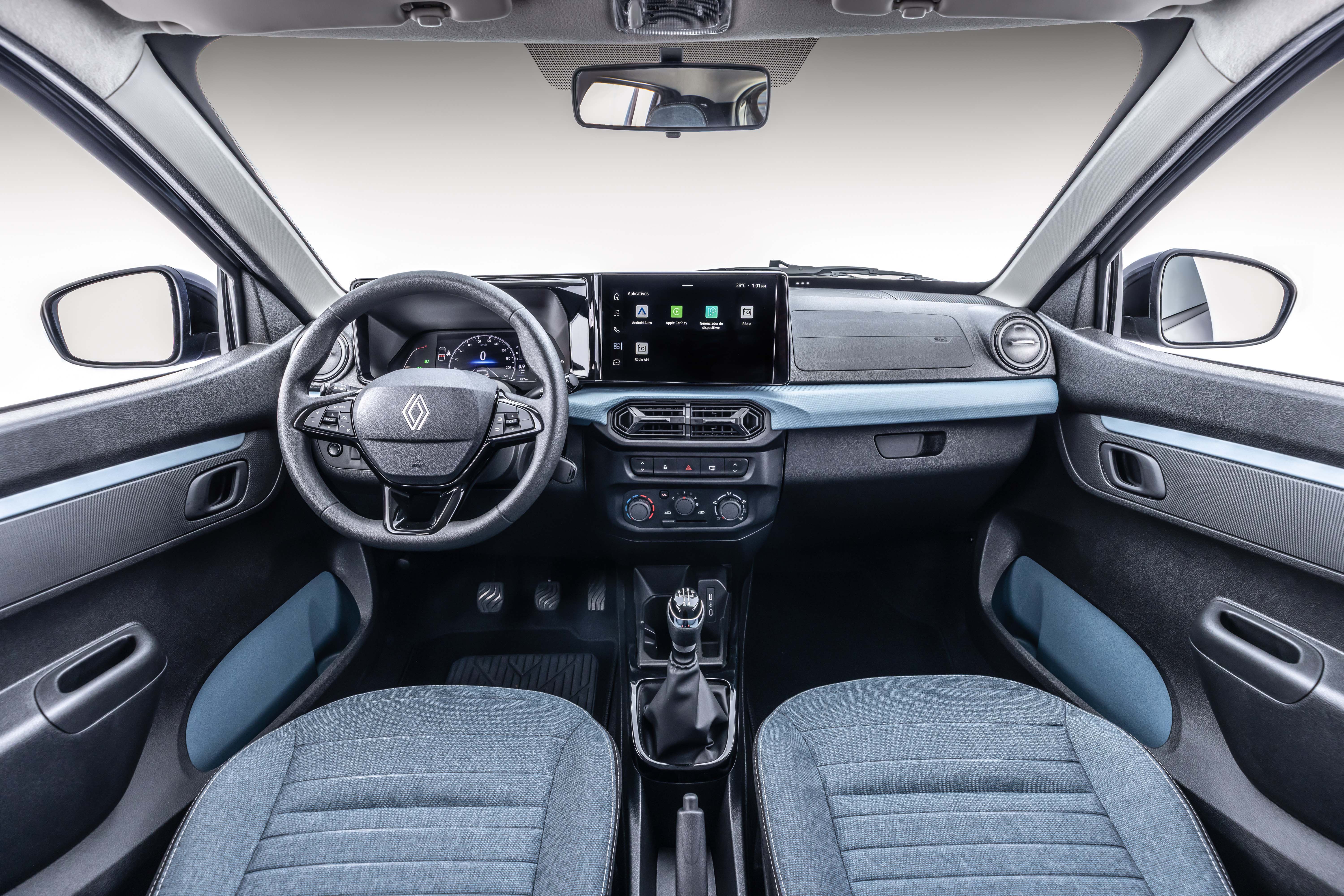 Interior de um carro, mostrando o painel frontal, volante com logo Renault, tela multimídia, câmbio manual e bancos de tecido cinza. Detalhes em azul claro no painel e nas portas contrastam com o preto predominante