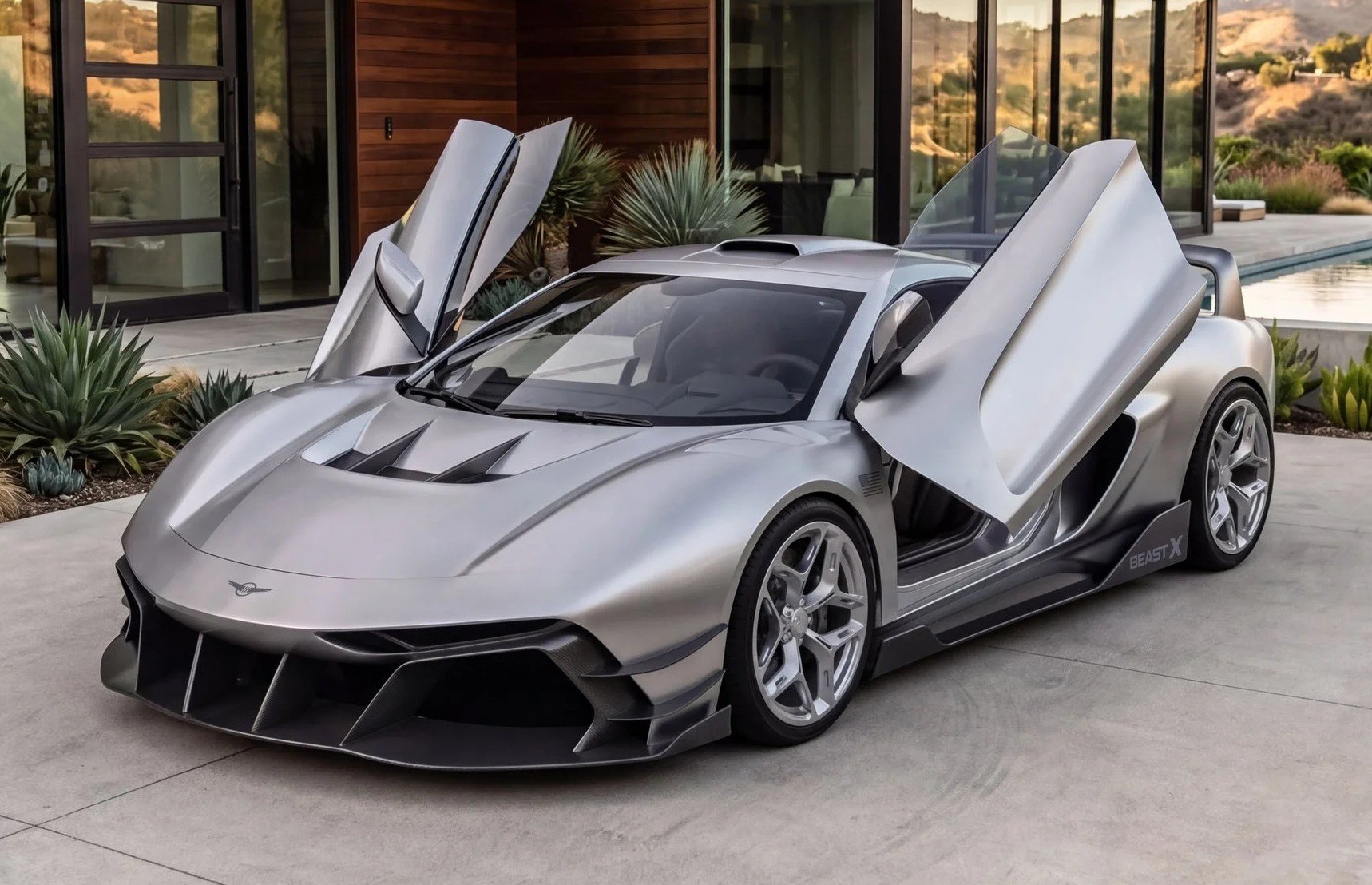 Carro esportivo prateado com portas abertas para cima, estilo asa de gaivota, estacionado em uma área externa com piso de concreto, em frente a uma casa moderna com paredes de madeira e vidro, e plantas suculentas ao redor. Ao fundo, uma piscina e montanhas distantes sob um céu claro