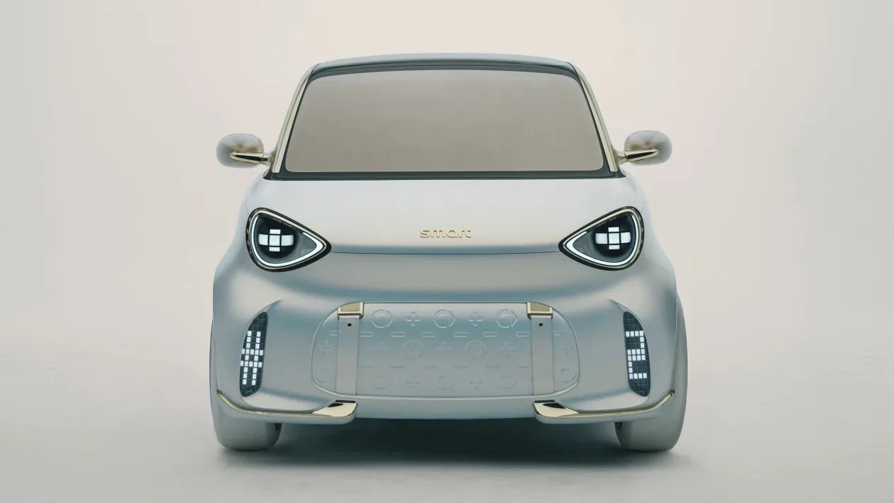 Carro elétrico Smart Concept #1 prateado, visto de frente, com faróis redondos e luzes diurnas em formato de pixels, sobre fundo branco