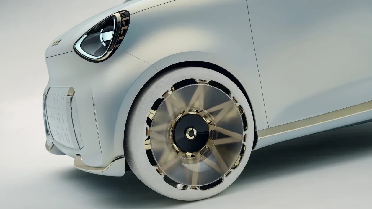 Parte frontal de um carro conceito branco, com farol oval e grade frontal texturizada. A roda dianteira tem um design futurista com raios dourados e uma cobertura transparente, sugerindo movimento