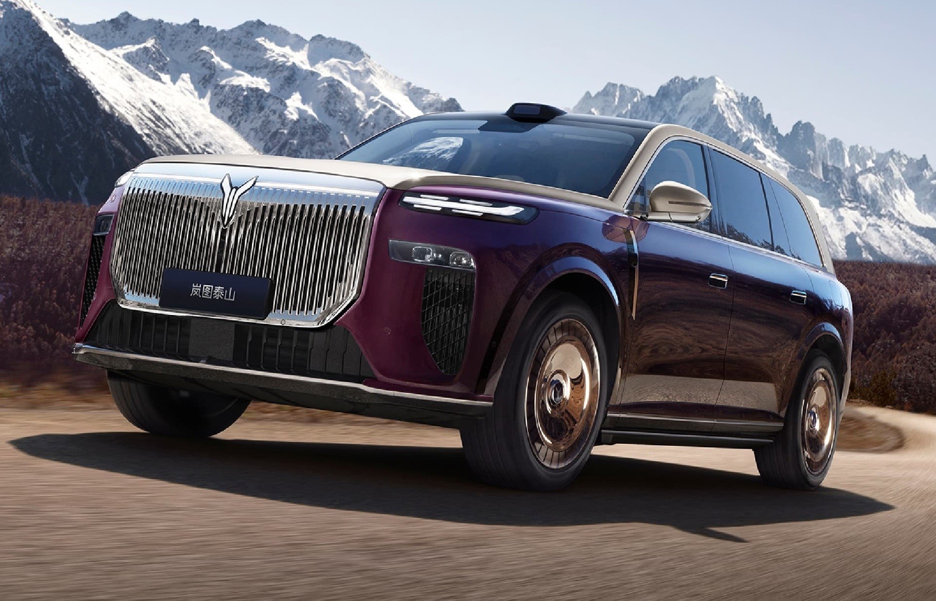 SUV de luxo roxo e bege com grade frontal cromada e rodas douradas, em uma estrada de terra com montanhas nevadas ao fundo