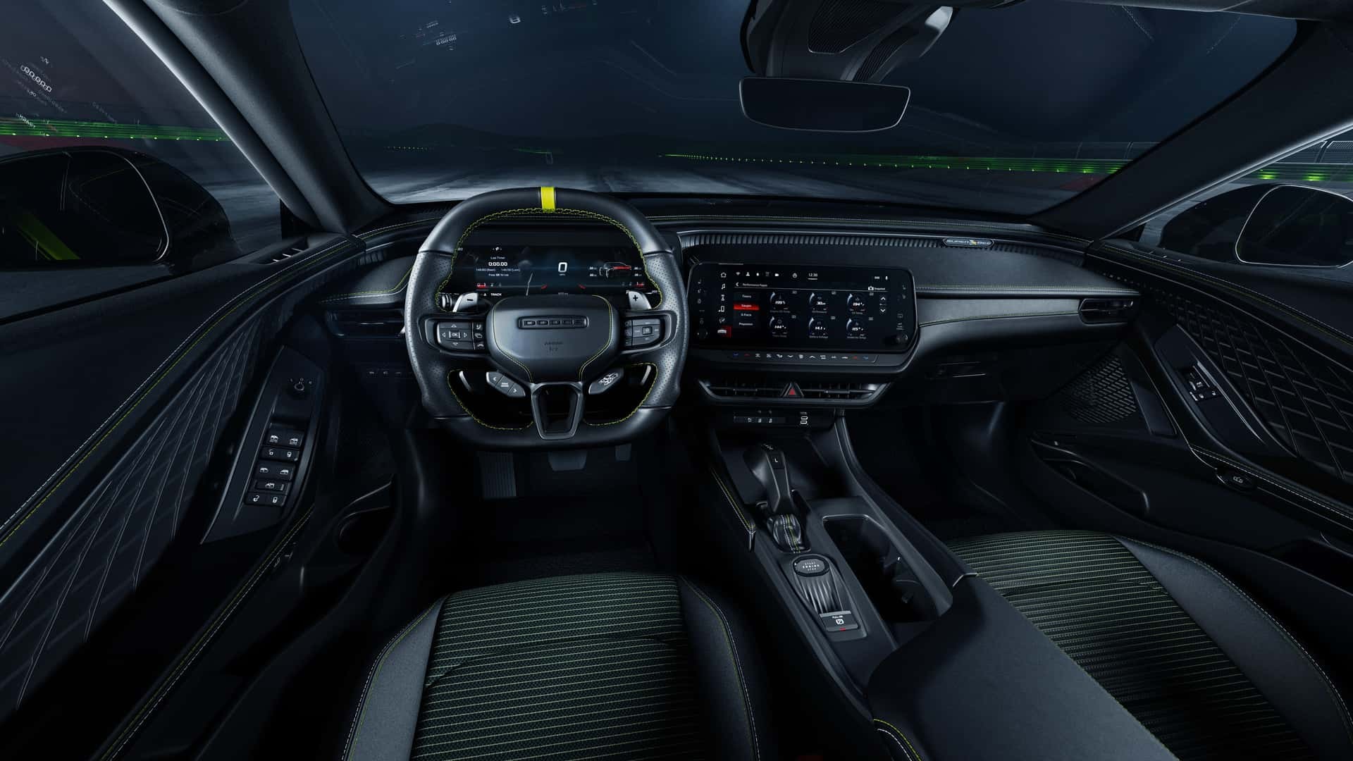 Interior de um carro esportivo moderno, com volante escuro e faixa amarela no topo, painel digital e tela multimídia. Os bancos são pretos com detalhes em verde escuro, e o ambiente é iluminado por luzes internas e externas, sugerindo movimento noturno