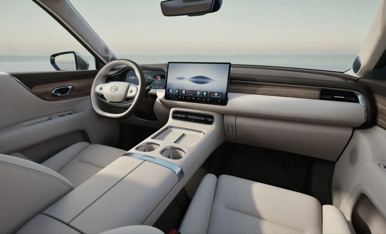 Interior de um carro moderno com estofamento claro e detalhes em madeira. O painel possui uma grande tela central sensível ao toque e um volante branco com botões. O console central tem porta-copos e acabamento metálico.