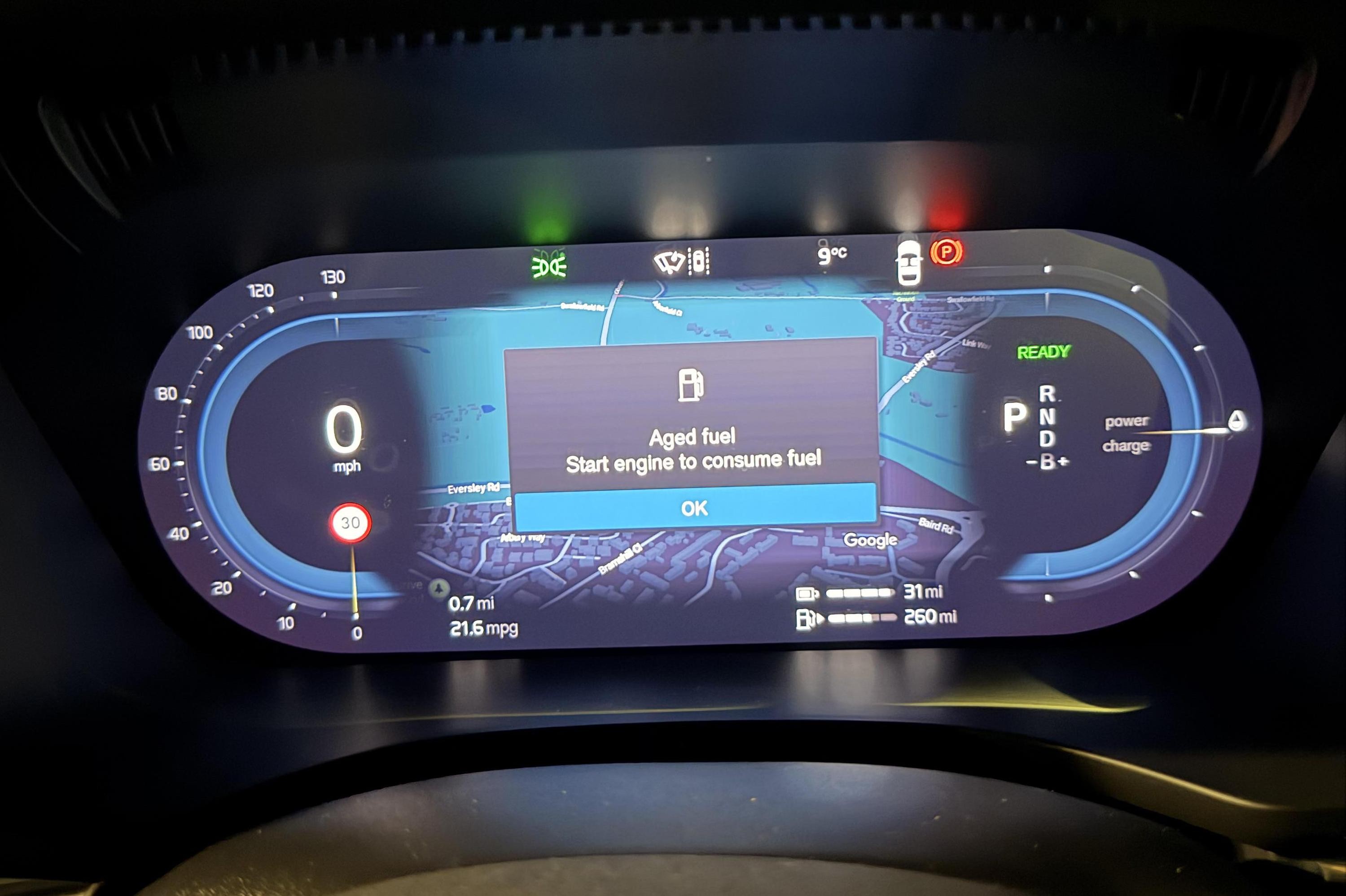 Painel digital de carro com velocímetro marcando zero, mapa de navegação e aviso Aged fuel. Start engine to consume fuel com botão OK