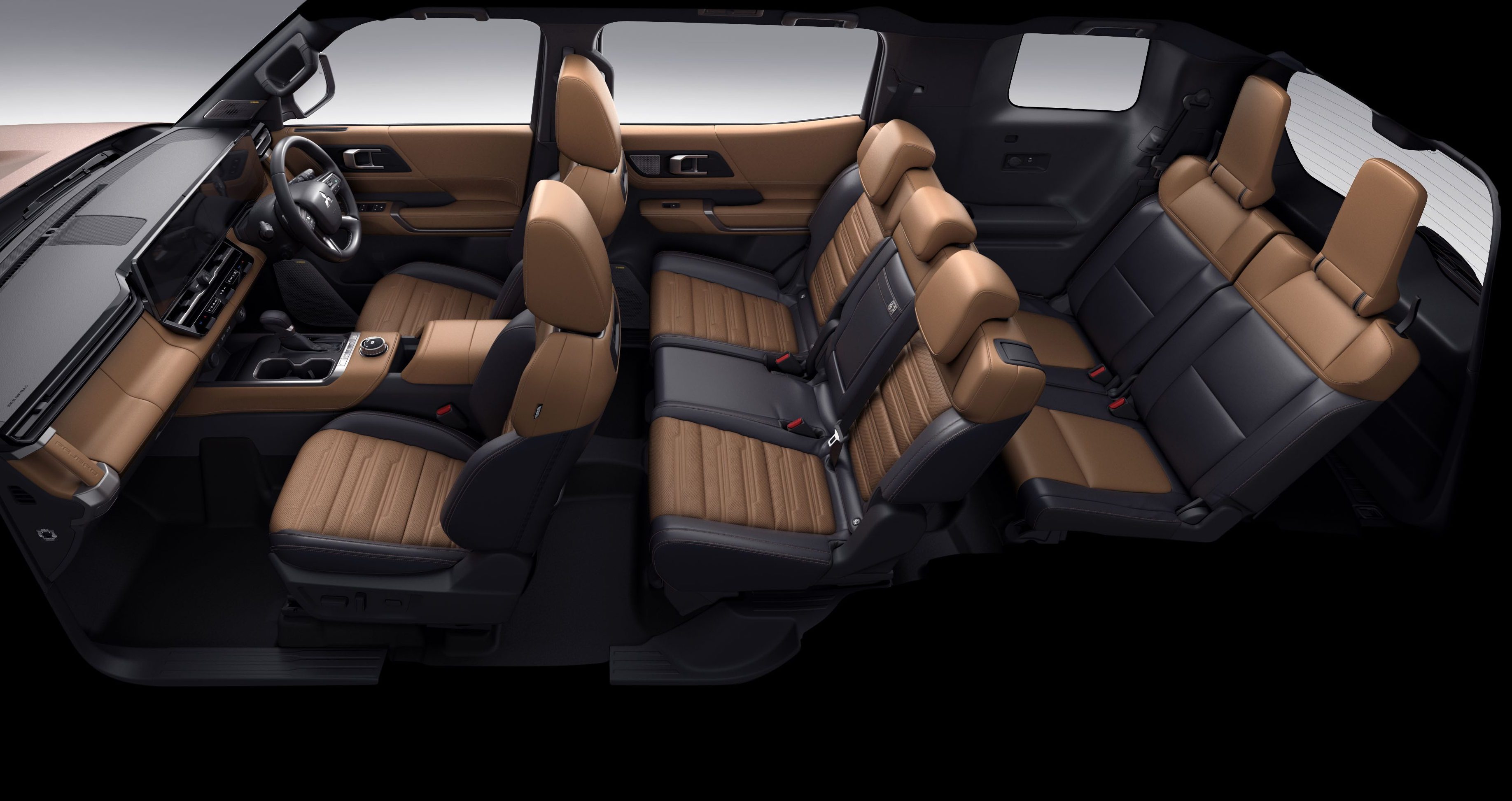 Interior de um carro com sete lugares, bancos em couro marrom e preto, painel e portas em tons de marrom. O volante está à esquerda, e os bancos traseiros estão rebatidos, mostrando a versatilidade do espaço