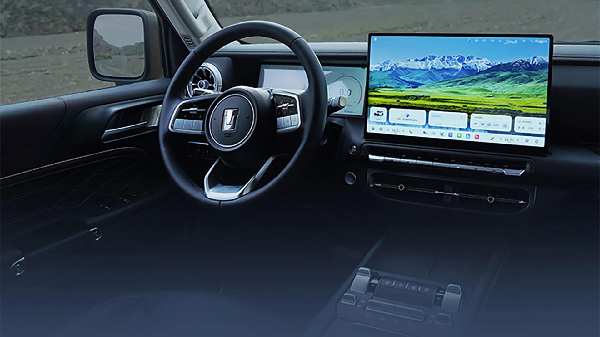 Interior de um carro moderno com volante preto e detalhes cromados, e uma tela multimídia grande exibindo uma paisagem de montanhas nevadas e campos verdes. O painel é escuro, com reflexos da tela na parte inferior. O retrovisor lateral esquerdo mostra uma paisagem embaçada.
