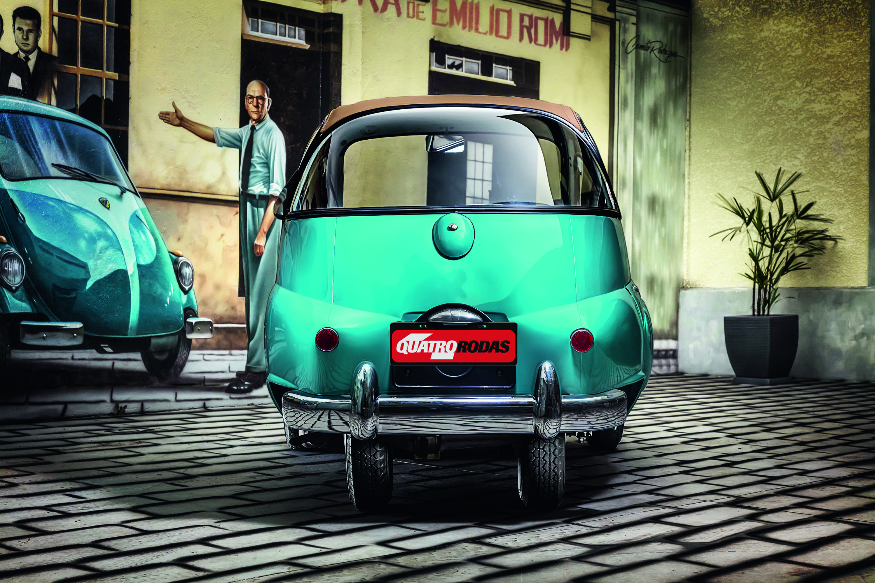 Dois carros antigos, um fusca azul-turquesa e um Isetta verde-água, estacionados em rua de paralelepípedos. Um homem de camisa clara e gravata escura aponta para o fusca. Ao fundo, uma parede amarela com letreiro e uma planta em vaso preto