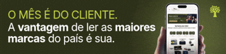 Mão segurando um smartphone com aplicativo de notícias exibindo O mês é do cliente. A vantagem de ler as maiores marcas do país é sua em fundo verde-escuro, com um ícone de árvore no canto superior direito