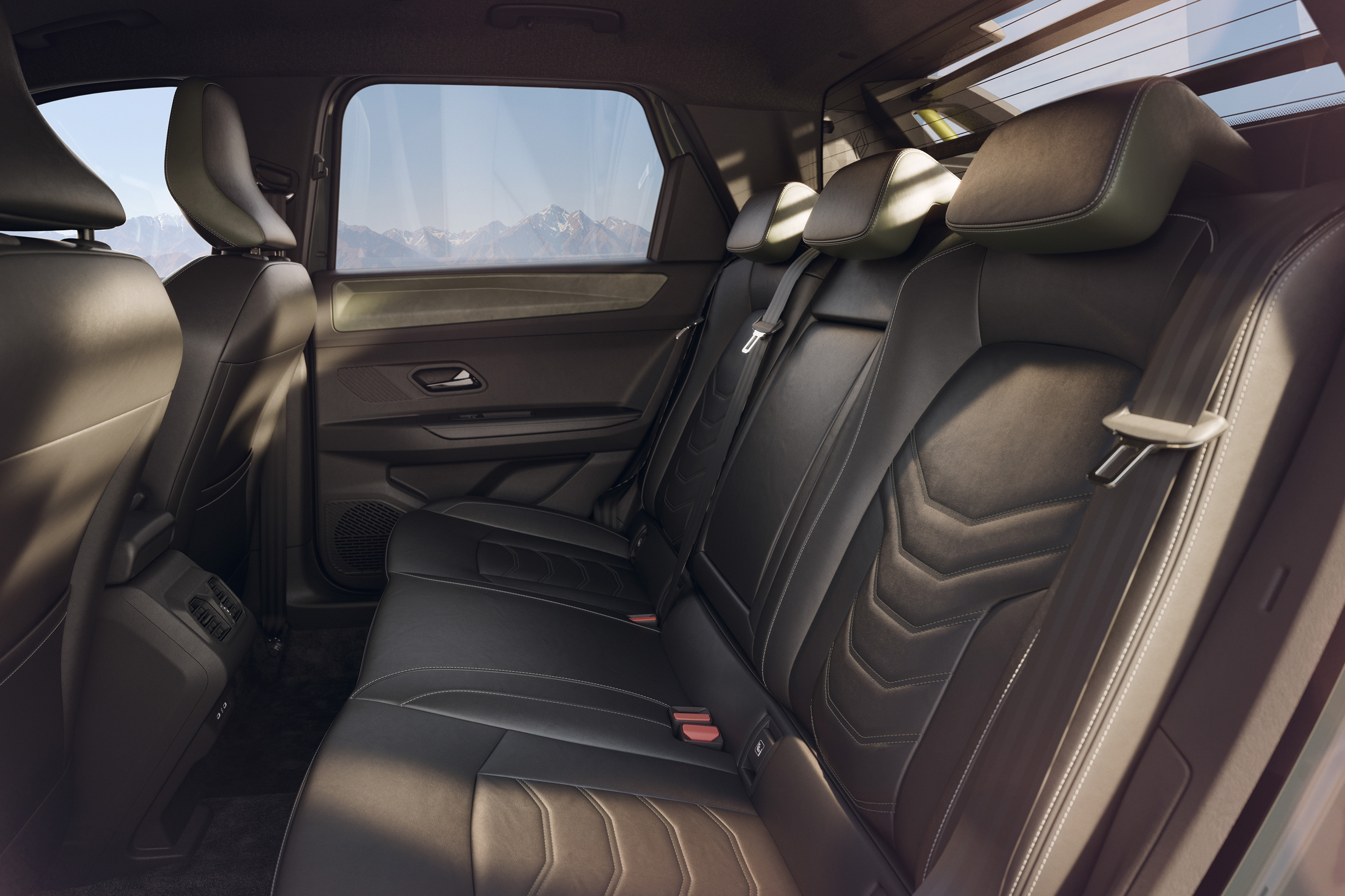 Interior de um carro com bancos traseiros de couro preto, costuras brancas e encostos de cabeça. A janela lateral exibe montanhas ao fundo sob um céu claro