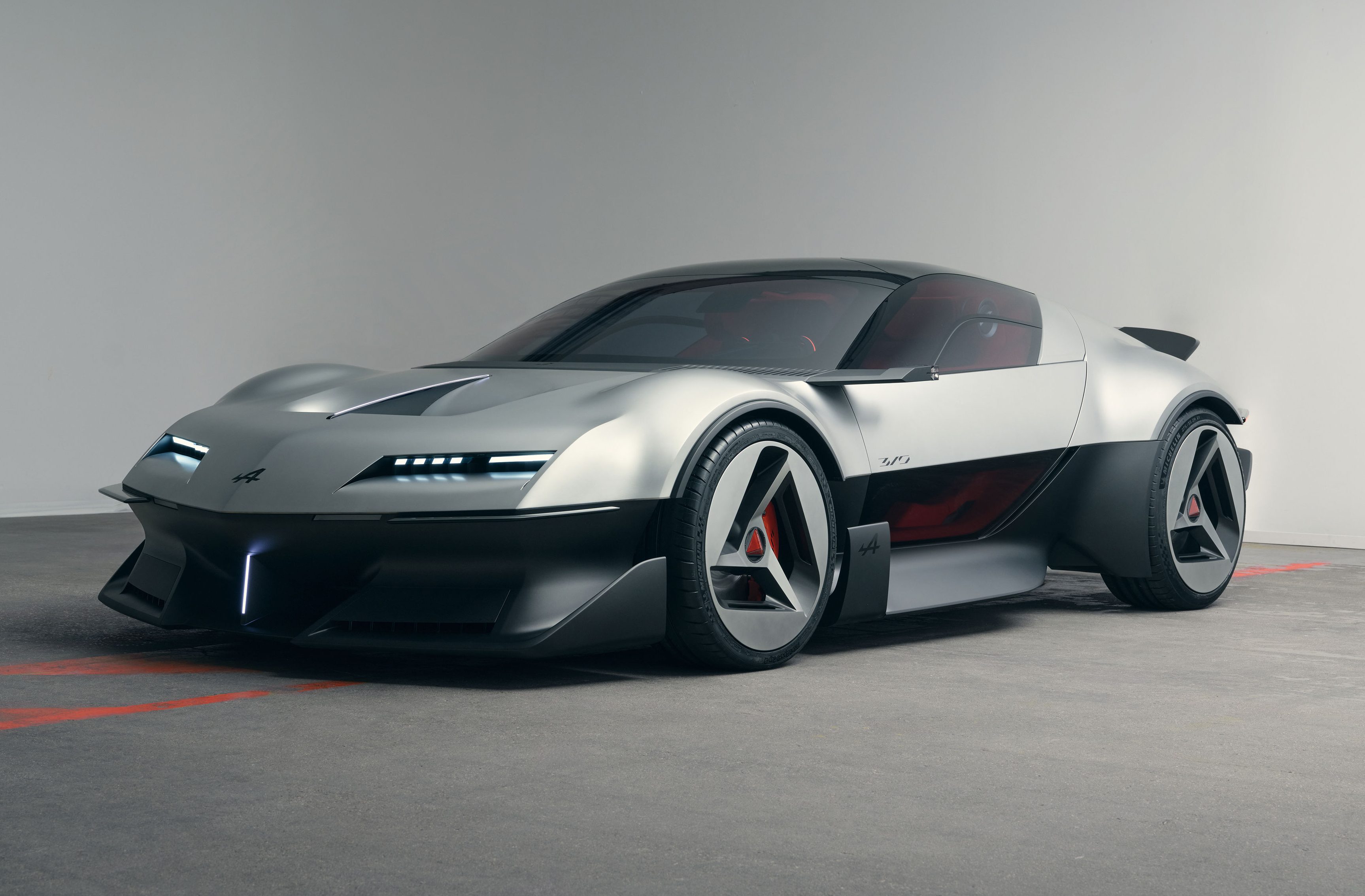 Carro esportivo conceito prateado e preto, com design futurista, faróis de LED finos e rodas aerodinâmicas, em um estúdio cinza claro