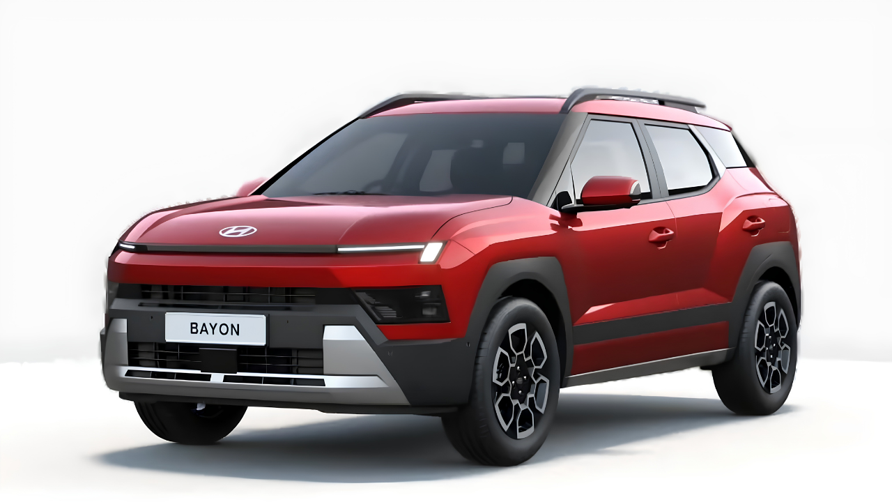 SUV Hyundai Bayon vermelho vibrante, com detalhes em cinza e preto na parte inferior, visto de frente e levemente de lado. O carro possui faróis finos e horizontais, rack de teto escuro e rodas com design geométrico. O nome BAYON aparece na placa dianteira.