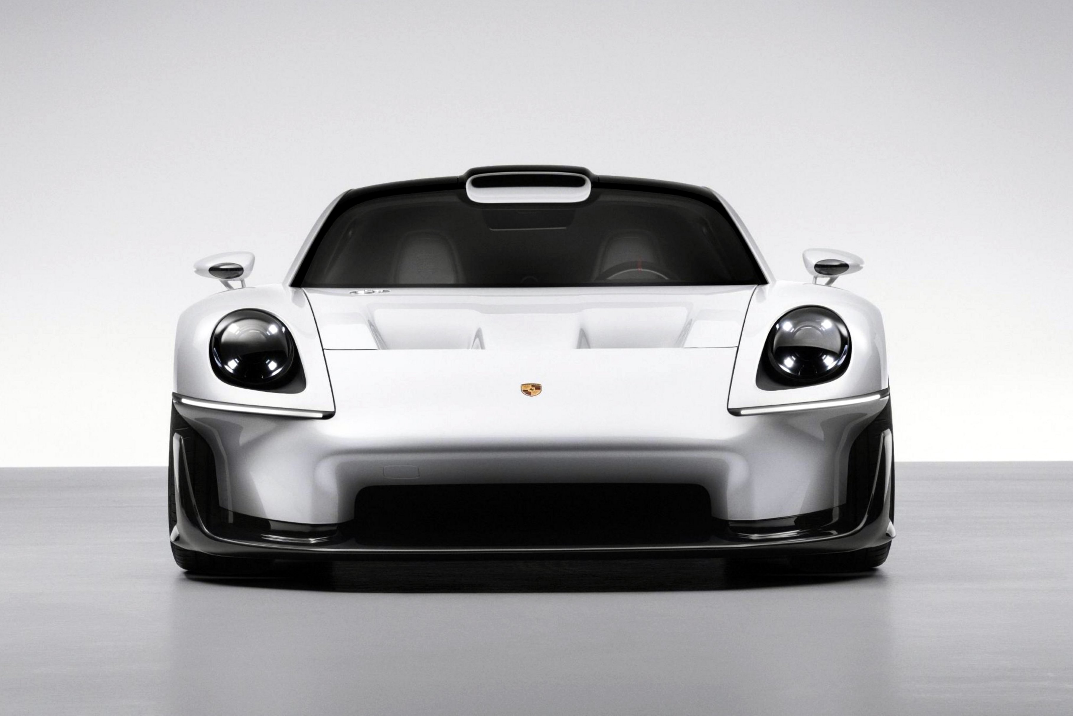 Carro esportivo Porsche branco e prateado, visto de frente, com faróis redondos e o emblema da marca no capô, sobre um fundo branco